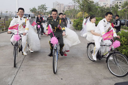 Twenty six newly wed couples held a group wedding on the first day of 2012 in Zhanjiang, Guangdong province, aiming to raise the public awareness of environmental protection and a low-carbon lifestyle. Li Manqing / for China Daily 