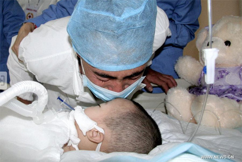 Feng Lei, gives her daughter Feng Junxi a final kiss at a hospital in Beijing, capital of China, June 9, 2012. A couple from Chifeng in north China's Inner Mongolia Autonomous Region decided to donate their daughter Feng Junxi's body organs after her death. Numerous people expressed their respect on line recently. (Xinhua) 