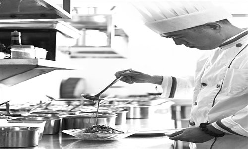 UFS and SFDA representatives launch the Food Safety Training Program for Catering Enterprises on June 19 in Beijing. A chef prepares a dish. [Photos: Courtesy of UFS]