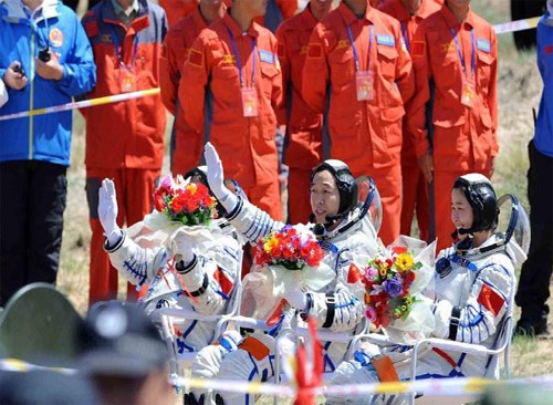 Chinese astronauts wave hands to greet welcoming crowd in Siziwang Banner of North China's Inner Mongolia autonomous region on June 29, 2012.[Photo/Xinhua]