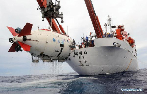 Technicians transfer China's manned submersible Jiaolong to its mother ship Xiangyanghong-9 in Pacific Ocean, June 30, 2012.