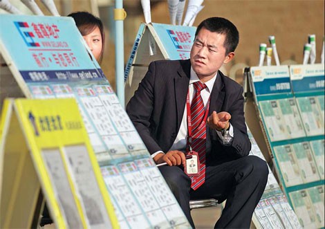 A real estate agent waiting for customers in Tiantongyuan in Beijing's Changping district. [Photo/China Daily]