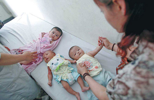 Medics check babies, freed from suspected traffickers, in a welfare center in Xingtai, Hebei province, on Wednesday. The infants were among 181 children who were rescued by police in a recent nationwide crackdown on human trafficking. [Photo: Ouyang Xiaofei / China Daily]