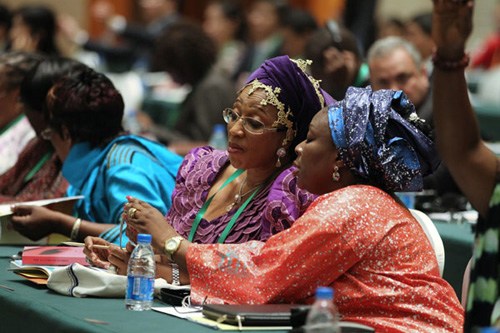 Two African delegates view pictures during the opening ceremony of the Second China-Africa People's Forum in Suzhou, Jiangsu province, on Tuesday. Vice-President Xi Jinping attended the ceremony and delivered a keynote speech. Feng Yongbin / China Daily