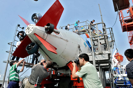 Visitors take pictures of manned submersible Jiaolong at a dock in Qingdao yesterday. [Shanghai Daily]