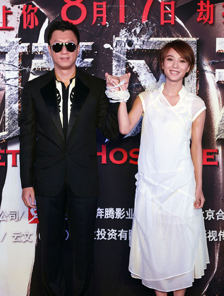 Cast members Sun Honglei (left) and Wang Luodan promote their film Lethal Hostage in Beijing on July 18, 2012. [Photo: mtime.com]