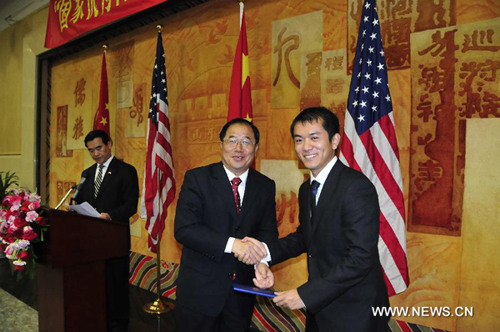 Deputy Consul General of the Chinese Consulate General in Houston Xie Yunliang (L, Front), shakes hands with a student during the award ceremony in Houston, the United States, on July 21, 2012. [Xinhua]