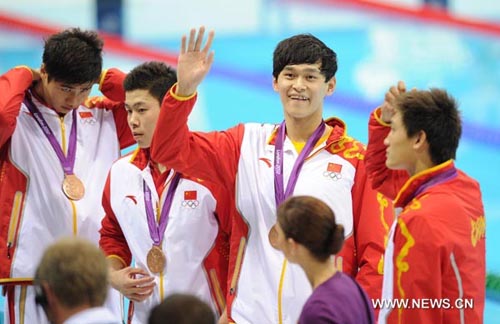 Sun Yang (2nd R) of China wave to his parents at the awarding ceremony of men's 4x200m freestyle relay of swimming at the London 2012 Olympic Games in London, Britain, July 31, 2012. Chinese swimmers won the bronze medal in this event. (Xinhua/Liu Dawei)