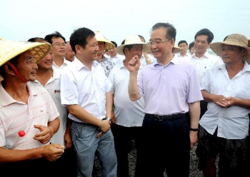 Chinese Premier Wen Jiabao talks with people battling the flood in Gong'an County, central China's Hubei Province, Aug. 2, 2012. Wen on Thursday concluded a two-day tour of Henan and Hubei provinces, where he inspected local flood control facilities and w