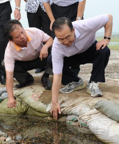 Chinese Premier Wen Jiabao checks preparation against piping on the Jingjiang Dike in central China's Hubei Province, Aug. 2, 2012. Wen on Thursday concluded a two-day tour of Henan and Hubei provinces, where he inspected local flood control facilities an
