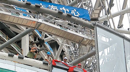 Workers yesterday install the double-layer glass walls at Shanghai Tower, to rise 632 meters over Pudong's Lujiazui area.