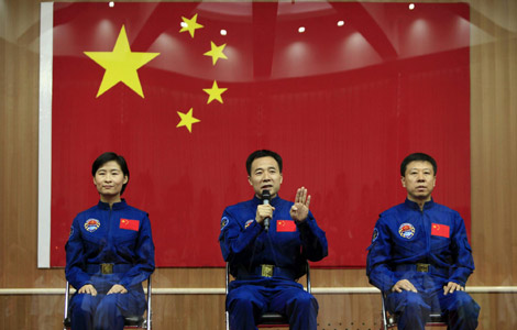 Chinese astronaut Jing Haipeng (C) answers a question next to Liu Wang (R) and Liu Yang, China's first female astronaut, during a news conference in a glass-shielded room at Jiuquan Satellite Launch Center, in northwest China's Gansu province, June 15, 20