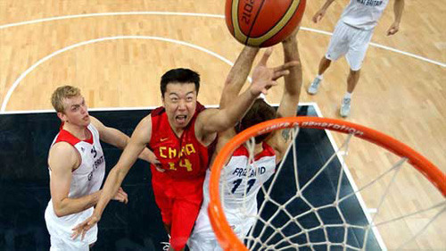Wang Zhizhi #14 of China drives for a shot through the Great British defence of Dan Clark #13 (L) and Joel Freeland #11 during their men's Basketball Preliminary Round match on Day 10 of the London 2012 Olympic Games. [Photo: Agencies]