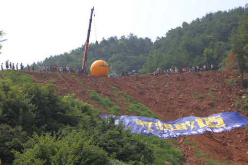 Yang Zongfu in Noah's Ark tumbles into the water from a 50-meter-high hillside in Yiwu couty, East China's Zhejiang province, Aug 6, 2012.