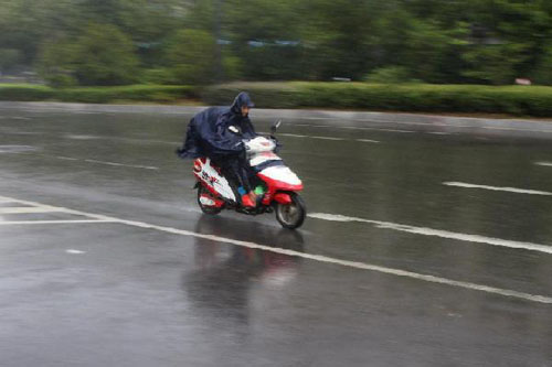 A man rides a motorcycle in rain caused by Typhoon Haikui in Hefei, capital of east China Anhui Province, Aug. 9, 2012. Typhoon Haikui entered Anhui on the night of Aug. 8 and it will linger in south Anhui on Aug. 9-10. (Xinhua/Zhang Duan)