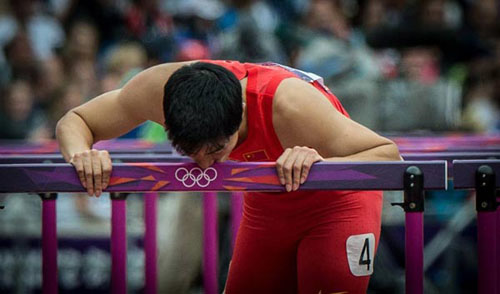 China's Liu Xiang kisses a hurdle after men's 110m hurdles heat at London 2012 Olympic Games, London, Britain, Aug. 7, 2012. Liu Xiang tumbled and was disqualified for semifinal.(Xinhua/Yang Lei)