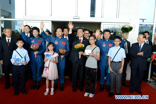 Niu Hongguang (C), deputy commander-in-chief of manned space program, astronaut Jing Haipeng (3rd L, 2nd row), Liu Wang (2nd R, 2nd row) and Liu Yang (2nd L, 2nd row) arrive in Macao, south China, Aug. 13, 2012. [Xinhua]