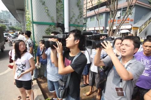 Cameramen film at the site where Zhou Kehua was shot dead in Chongqing on Tuesday. Yang Fan / for China Daily
