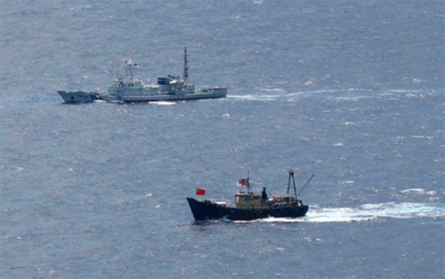 A Japan Coast Guard patrol ship sails around a fishing boat (R) carrying activists from the Hong Kong near the Diaoyu Islands in the East China Sea, in this handout photo taken by the Japan Coast Guard August 15, 2012.[Photo/Agencies]