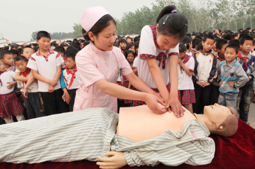 A nurse teaches cardiopulmonary resuscitation to students at No 2 Central Primary School in Tashan township, Ganyu county, Jiangsu province, in June. Si Wei / for China Daily