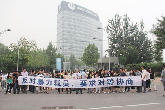 Staff members of Motorola Mobility Holdings Inc in Beijing protest in front of the company's office building on Friday demanding consultation on an equal footing.