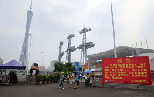 Tourists pass by a sign in front of Haixinsha Park announcing the cancelation of free carnivals for the Qixi Festival at Guangzhou, Guangdong province on Monday. Zou Zhongpin / China Daily