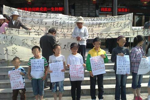 A group of 13 children drew widespread attention in China last week by helping their parents claim wages held in arrears. [Photo: cnr.cn]