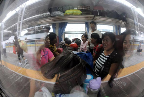 50 female cotton pickers from Heze city, Shandong province sit on the special train bound for Xinjiang Uygur autonomous region on August 20, 2012 at Shangqiu Railway Station. [Photo/Xinhua] 