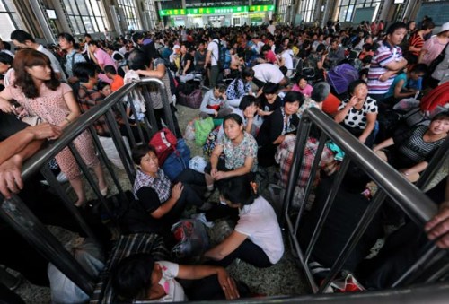 Cotton pickers wait for ticket checks on August 20, 2012 in the waiting room of Zhengzhou Railway Station. [Photo/Xinhua]