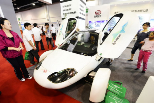 Visitors examine an Aptera electric car developed by Zhejiang Jonway Automobile Co Ltd at the 2012 China International Green Vehicle Industry Expo in Hangzhou, Zhejiang province, on Aug 10. China expects production and sales of electric vehicles to reach 