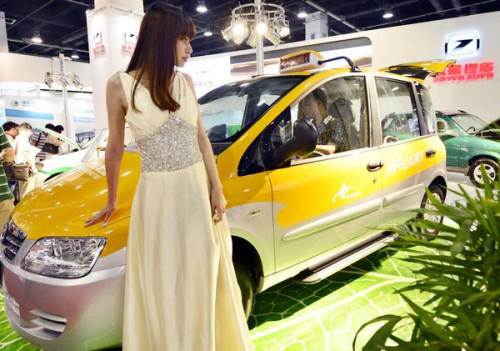 A model poses beside an electric car at the 2012 China International Green Vehicle Industry Expo in Hangzhou, Zhejiang province, on Aug 10. China expects production and sales of electric vehicles to reach 5 million by 2020. [Photo/China Daily] 