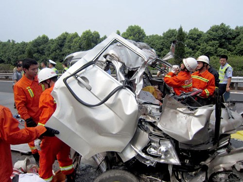Rescuers clean up the wreckage of a van, which rear-ended a truck in Guang'an, Sichuan province, on Sunday. All 12 people in the van were killed in the accident. Tan Chunchu / for China Daily