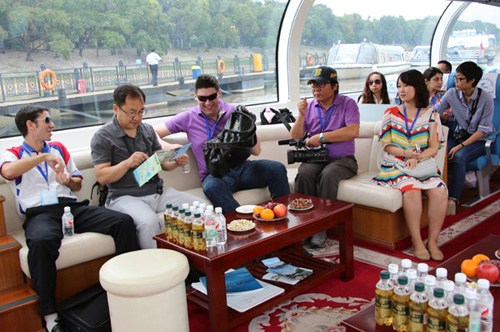 Reporters from various Asian media outlets enjoy their leisure time aboard a yacht on the Songhua River in Harbin, Northeast China's Heilongjiang province, on Wednesday. Zhao Tianhua / for China Daily