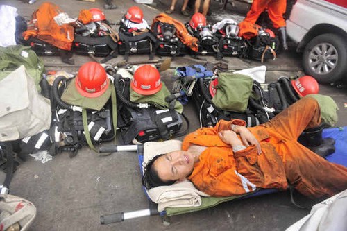 A rescuer takes a nap in a stretcher on Friday at the Xiaojiawan Coal Mine in Panzhihua, Sichuan province. Lu Jia / for China Daily 