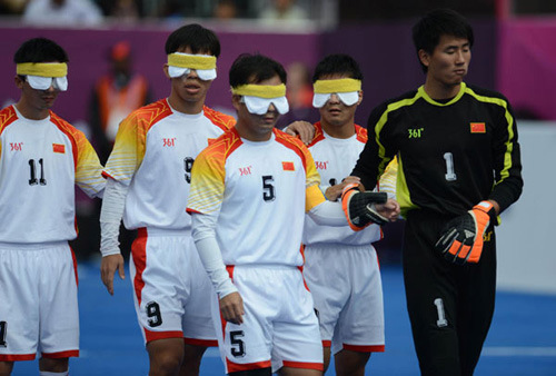 China's 5-a-side football team enter the field, guided by goalkeeper Xu Huachu, right, before their football 5-a-side Group B match against France at the London Paralympic Games, Sept 2, 2012. [Photo/Xinhua]