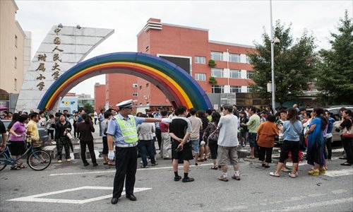 Parents protest at the gate of The Elementary School Affiliated to Renmin University of China in Haidian district Sunday. Photo: Li Hao/GT 