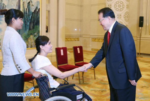 Li Changchun (R), a Standing Committee member of the Political Bureau of the Communist Party of China (CPC) Central Committee, meets with Zhang Lili (C), a teacher who lost her legs while saving two students from an onrushing bus, prior to a seminar held 