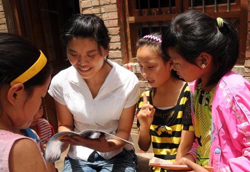 Li Ling reads books with her students in Xuwan village, Zhoukou city. Chang Liang / for China Daily