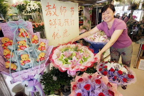 A flower shop owner in Nanjing, capital city of Jiangsu province, showing her well-packaged bundles of flowers and expecting good business a few days ahead of the country's Teachers' Day. [Photo/China Daily] 