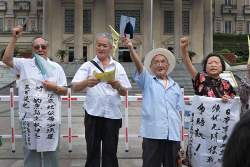 Survivors of the Japanese mass bombing of Chongqing, between 1938 and 1944, protest outside a Chongqing court against Japan's wartime actions and Tokyo's plan to nationalize China's Diaoyu Islands on Monday. Survivors of the bombing have filed a lawsuit against Tokyo. Yu Changjiang / For China Daily  