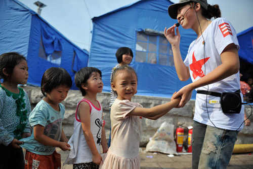 A teacher plays with children at a makeshift kindergarten in a relocation site for quake victims in Yiliang, Yunnan province.LIU RANYANG / CHINA NEWS SERVICE