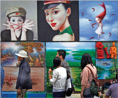 Visitors at a small outdoor market walk past paintings for sale in Beijing on Sept 8. [Photo/Agencies]