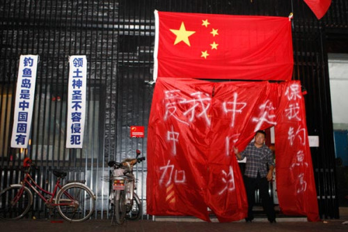 The national flag and patriotic slogans cover the outside of a Japanese restaurant in Chaoyang, Beijing. Many Japanese businesses in China closed their doors amid protests against Japan. Zhu Xingxin / China Daily