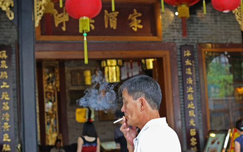 Guangzhou's revised regulation, which took effect on Sept 1, authorizes chengguan, officers who enforce city laws, to immediately issue a 50 yuan ($7.9) fine for smoking in public places. CHEN QIUMING / YANGCHENG EVENING NEWS