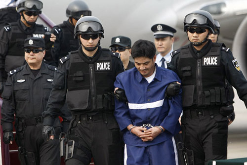 Naw Kham, leader of a notorious gang on the Mekong River on arrival at Beijing airport on May 10 after he was formally transferred to Chinese police by the Laotian authorities. He will stand trial in Kunming, capital of Southwest China's Yunnan province, 