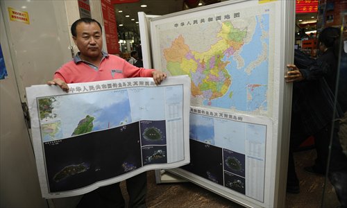 A customer holds up the map of the Diaoyu Islands at the Wangfujing Bookstore Wednesday. The map went on sale Wednesday in Beijing. Photo: Li Hao/GT 