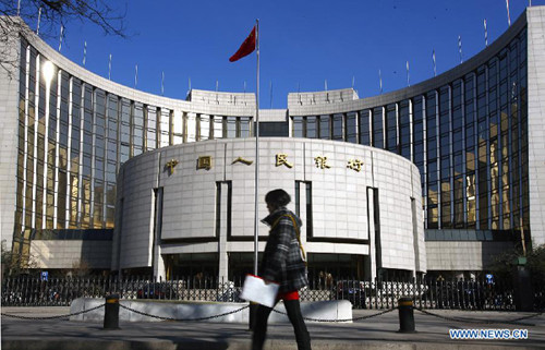 A file photo taken on Feb. 23, 2012 shows a pedestrian walking past the headquarters building of the People's Bank of China in Beijing, capital of China. (File photo)