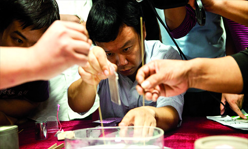 Owners of crickets focus on making sure their insect is the winner. Photos: Guo Yingguang/GT 