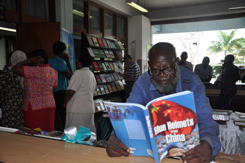 A man reads a book donated by the Experience China project at the National Central Library of Tanzania in Dar es Salaam on Monday. Liu Xiangrui / China Daily