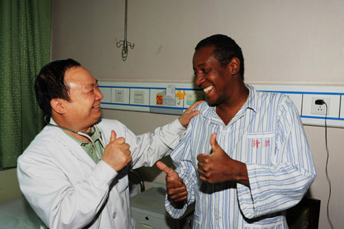 Zhuang Shihua talks to a Brazilian patient in a hospital in Urumqi, Xinjiang Uygur autonomous region, June 18, 2012. [Photo/Xinhua] 